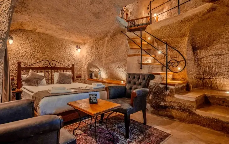 Aydınlı Cave Hotel mağara oda içi görünümü, kaya oyma tavan ve Kapadokya taş konaklama atmosferi